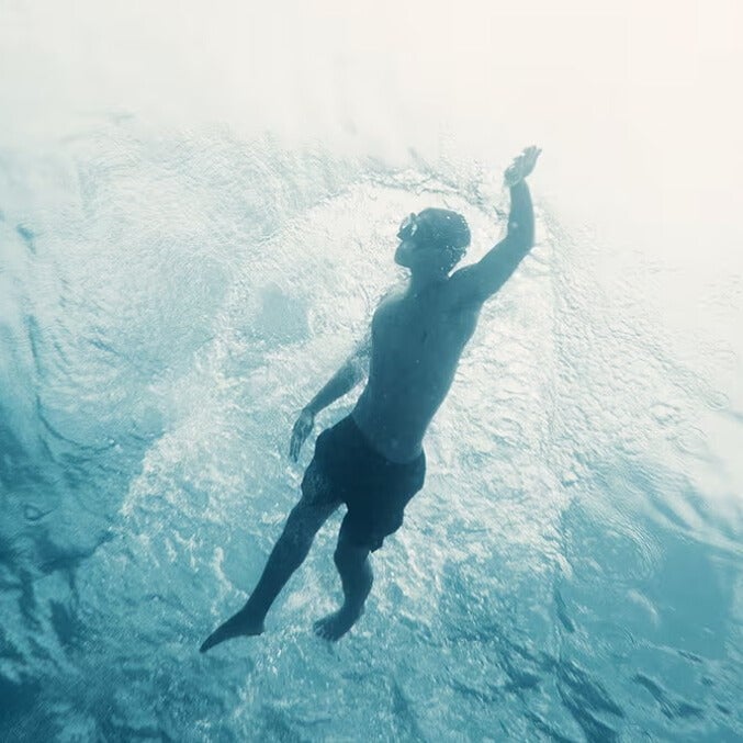 Athlete swimming underwater wearing Ten Thousand Set Short, showcasing quick-drying, water-ready design.