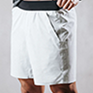 Person wearing white athletic shorts with hands on hips.